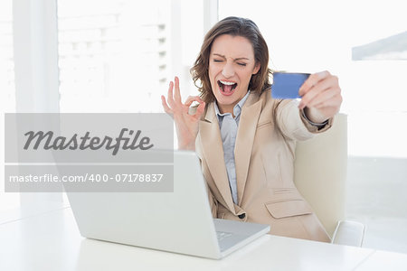 Businesswoman doing online shopping through laptop and credit card in office