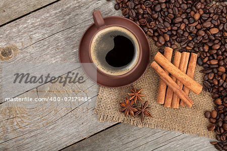 Coffee cup and spices on wooden table texture. View from above