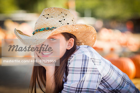 Preteen Girl Wearing Cowboy Hat Portrait at the Pumpkin Patch in a Rustic Setting.