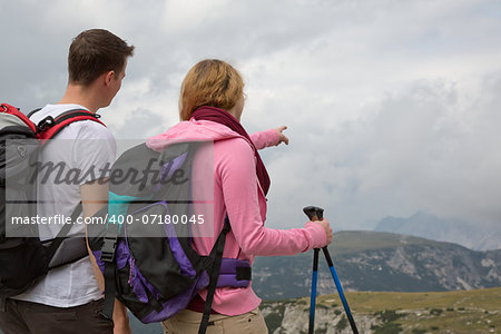 Young backpackers searching the destination in the mountains while hiking