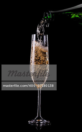 Golden champagne pouring in glass from a bottle
