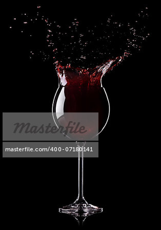 Wine splashing from a wine-glass on black background