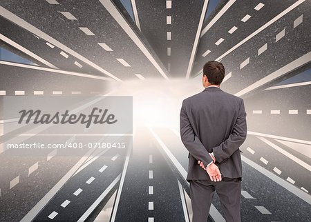 Composite image of businessman standing with hands behind back with streets running together in background
