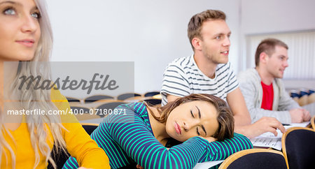 Young college students sitting in the classroom with one asleep girl