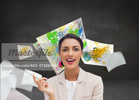 Composite image of smiling businesswoman holding a pen