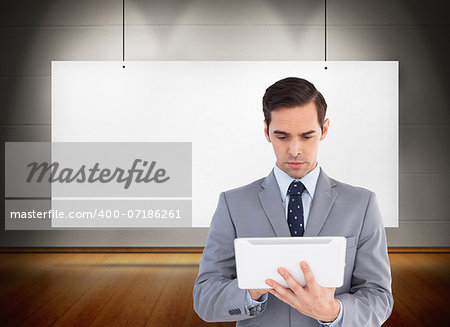 Composite image of businessman holding a tablet computer