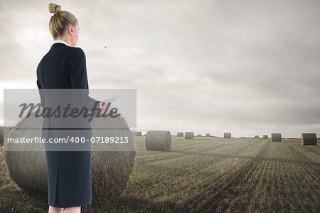 Composite image of blonde businesswoman holding new tablet