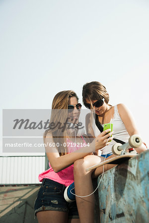 Girls Looking at MP3 Player in Skatepark, Feudenheim, Mannheim, Baden-Wurttemberg, Germany