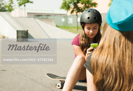 Girls using Cell Phone in Skatepark, Feudenheim, Mannheim, Baden-Wurttemberg, Germany