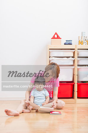 Mother reading to baby on floor