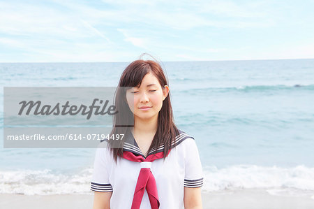 Young woman on beach with eyes closed