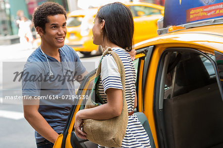 Man opening cab door for woman