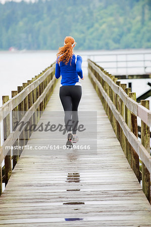 Teenage girl jogging on pier, Bainbridge Island, Washington, USA