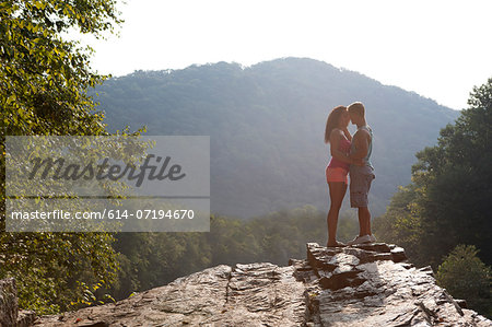 Young couple kissing on rock ledge, Hamburg, Pennsylvania, USA