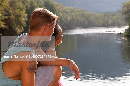 Young couple sitting by river, Hamburg, Pennsylvania, USA Young couple sitting by river, Hamburg, Pennsylvania, USA