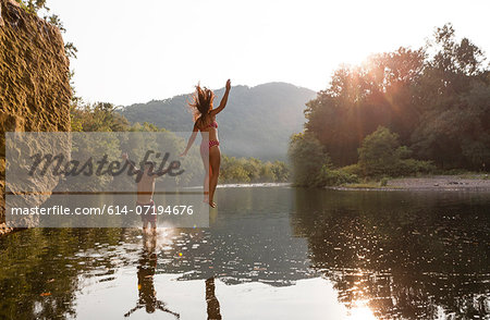 Young couple jumping into river, Hamburg, Pennsylvania, USA Young couple jumping into river, Hamburg, Pennsylvania, USA