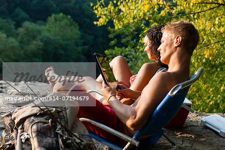 Young couple relaxing on rock ledge, Hamburg, Pennsylvania, USA