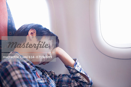 Boy asleep on aeroplane