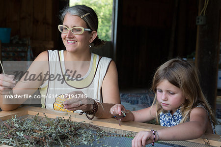 Mother and daughter sorting dried herbs