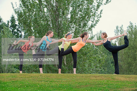 Teenage girls and yoga tutor standing on one leg