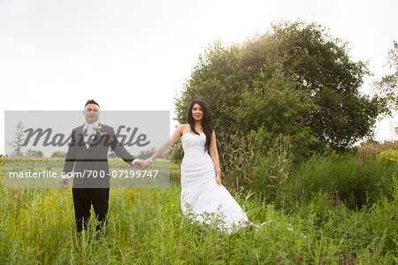Portrait of Bride and Groom Holding Hands Outdoors