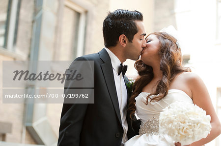 Portrait of Bride and Groom Kissing Outdoors