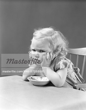 1940s UNHAPPY GRUMPY LITTLE BLONDE GIRL SITTING IN HIGHCHAIR REFUSING TO EAT