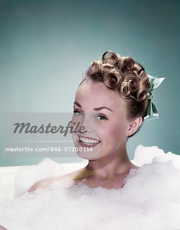 1940s PORTRAIT SMILING TEEN GIRL IN BUBBLE BATH LOOKING AT CAMERA