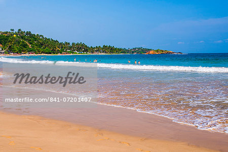 Golden sands and blue waters of the Indian Ocean at Mirissa Beach, South Coast, Sri Lanka, Asia
