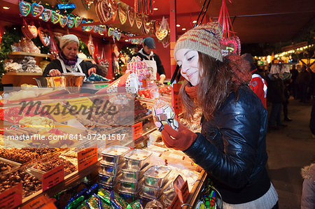 Young woman at the Christmas Fair looking at gingerbread, Esslingen am Neckar, Baden Wurttemberg, Germany, Europe