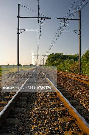 Train track and overhead cables  at  level crossing near Barsac station, Bordeaux  region, France.