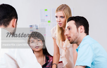 Close-up of group of young business people in meeting in office, Germany