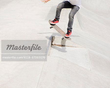 A teenage boy balancing on a skateboard in the city.