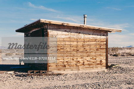 A small abandoned building in the Mojave desert landscape.