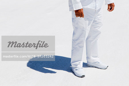 A man in white overalls, a race official timekeeper at a car racing event, at Speed Week on Bonneville Salt Flats.