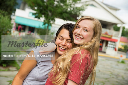 Two girls hugging and laughing.