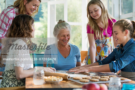 Farmhouse in the country in New York State. Four generations of women in a family baking together.