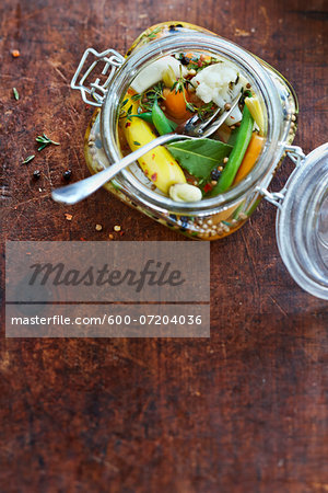 Overhead Shot of Antique Jar of Pickled Vegetable Relish with Green Beans, Carrots, Cauliflower, Thyme, Bay Leaf, Peppercorns and White Onions in Vinegar