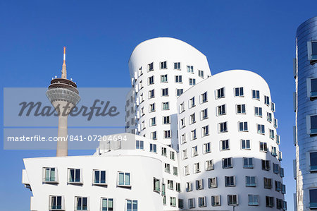 Neuer Zollhof, designed by Frank Gehry, and Rheinturm tower, Media Harbour (Medienhafen), Dusseldorf, North Rhine Westphalia, Germany, Europe