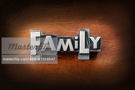The word family made from vintage lead letterpress type on a leather background.