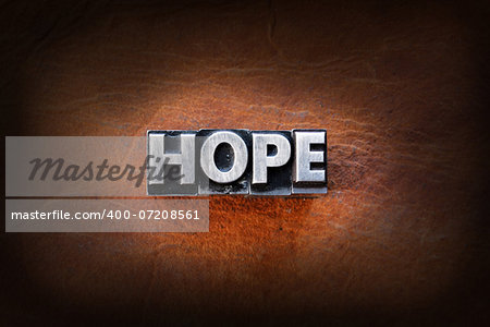 The word hope made from vintage lead letterpress type on a leather background.