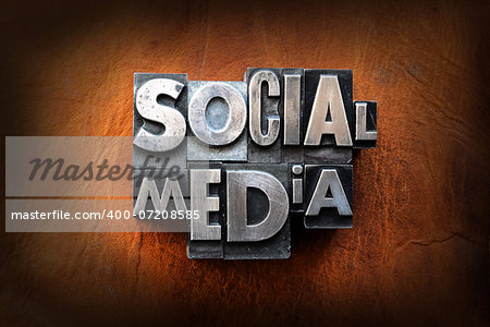 The words social media made from vintage lead letterpress type on a leather background.