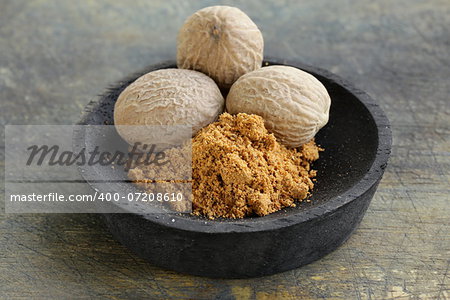 nutmeg whole and grated in a wooden bowl