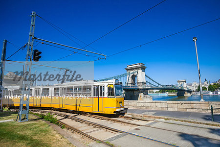Yellow tram on the river bank of Danube and Chain Bridge in Budapest, Hungary