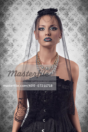 cute blonde girl wearing gothic clothes, dark veil on the face and bizarre make-up for halloween day