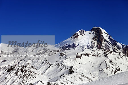 Mount Kazbek at sun winter day. Caucasus Mountains, Georgia, view from ski resort Gudauri.