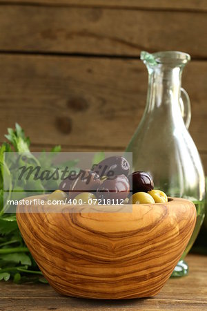 marinated green and black olives (Kalamata) in a wooden bowl