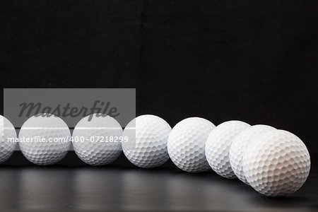 Different golf balls on the black table