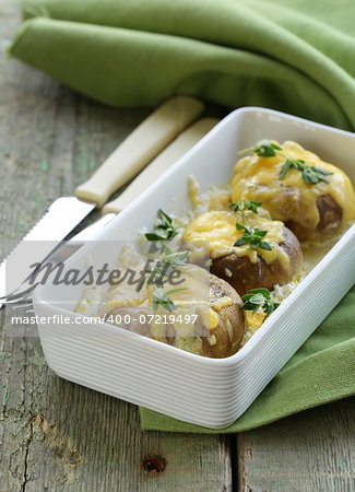 mushrooms baked with cheese, thyme served  on a wooden table