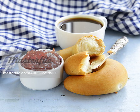 strawberry jam and bread rolls with a cup of coffee for breakfast